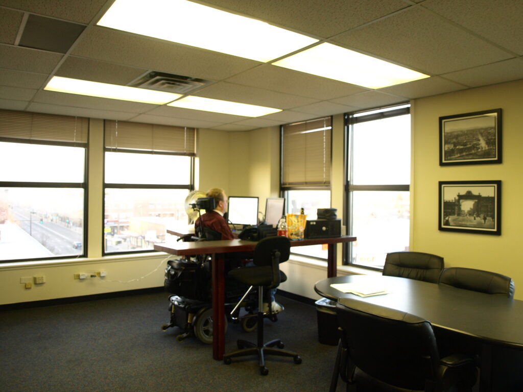 Tim's spacious corner office with his desk, a conference table and massive windows. 